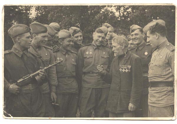 Георгиевский кавалер бывший артиллерист Алексей Манилович Шамриха среди советских солдат. 1943 год.