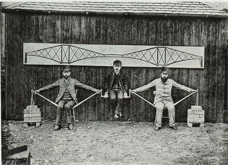 Трое мужчин демонстрируют систему консольного моста. По этой схеме был построен мост Forth Bridge через залив Ферт–оф–Форт у восточного берега Шотландии, 1882 год   