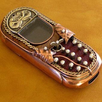 Сочетание красной меди, мелких жемчужин и мелкого серебрянного орнамента делают этот телефон романтичным символом прошедшей эпохи галантности и гламура. 