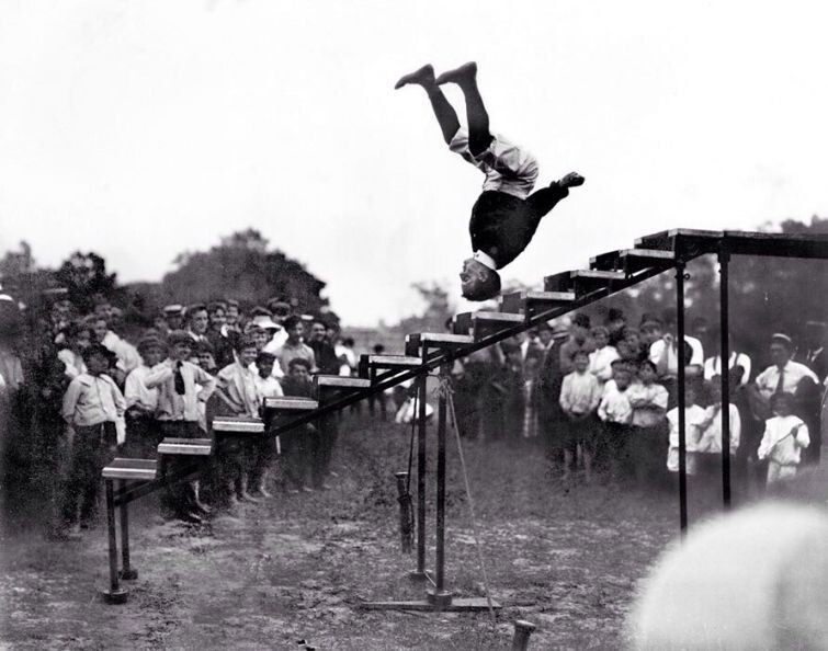 Американский циркач Александр Пэтти спрыгивает по ступенькам вниз головой во время выполнения трюка, 1908 год