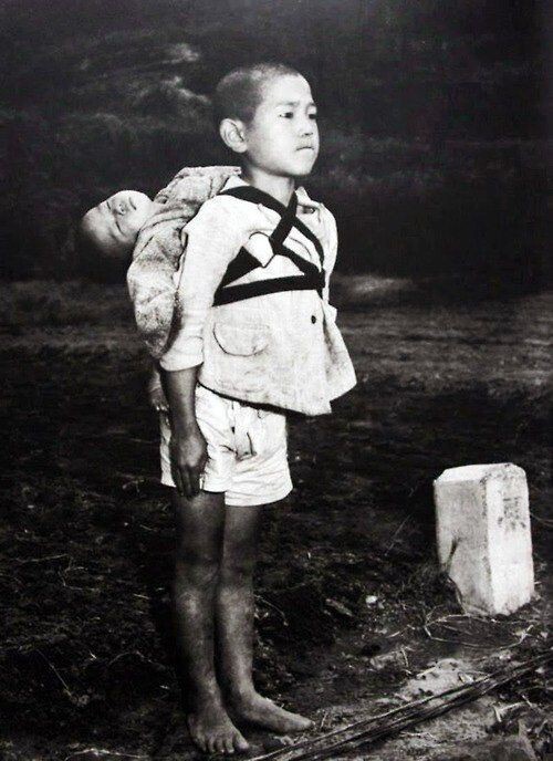 Японский мальчик принес тело своего погибшего брата на кремацию. Нагасаки, 1945 год