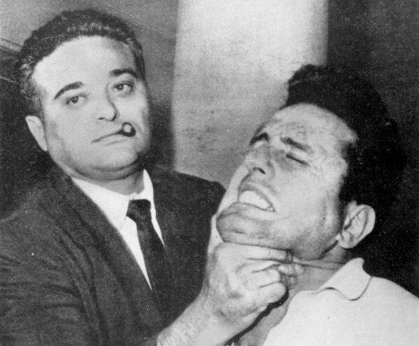 Капитан нью-йоркской полиции Альберт Сидмен помогает фотографу запечатлеть лицо подозреваемого в убийстве. 1962 год