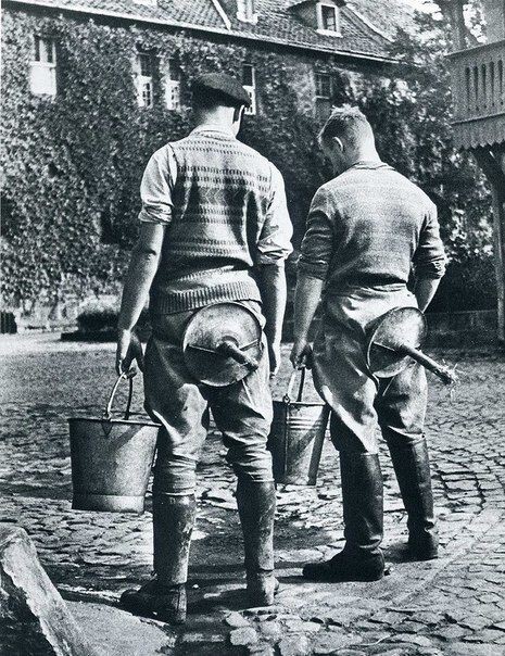 Студенты сельскохозинститута со стульями для дойки. Германия, Нойдек, 1934 год