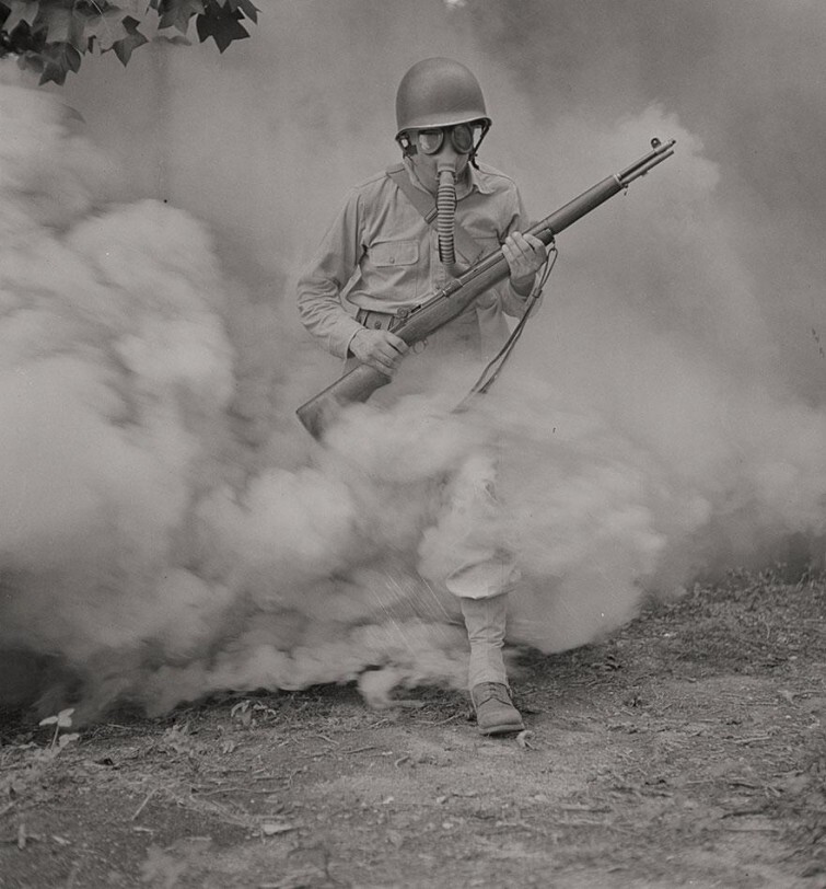 Солдат в противогазе проходит сквозь дымовую завесу