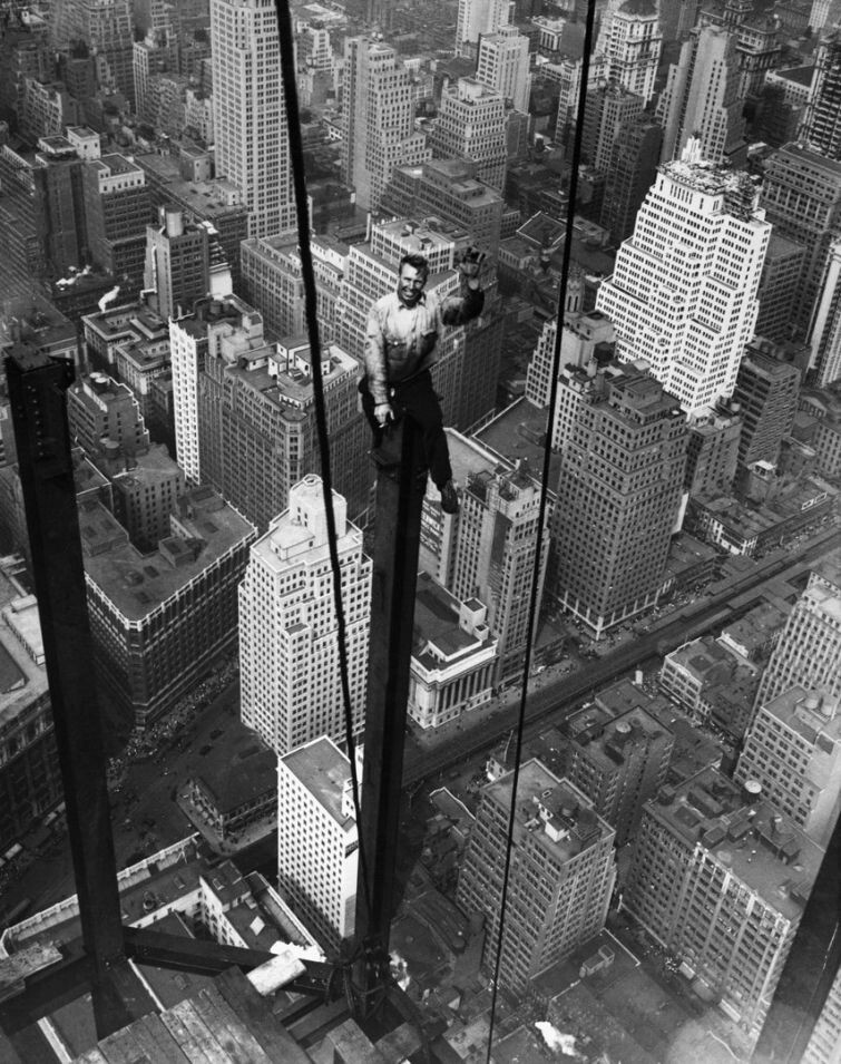 Рабочий Карл Рассел приветствует друзей с балки на высоте 88 этажа во время строительства 102-этажного небоскреба Empire State Building, 13 сентября 1930 года.