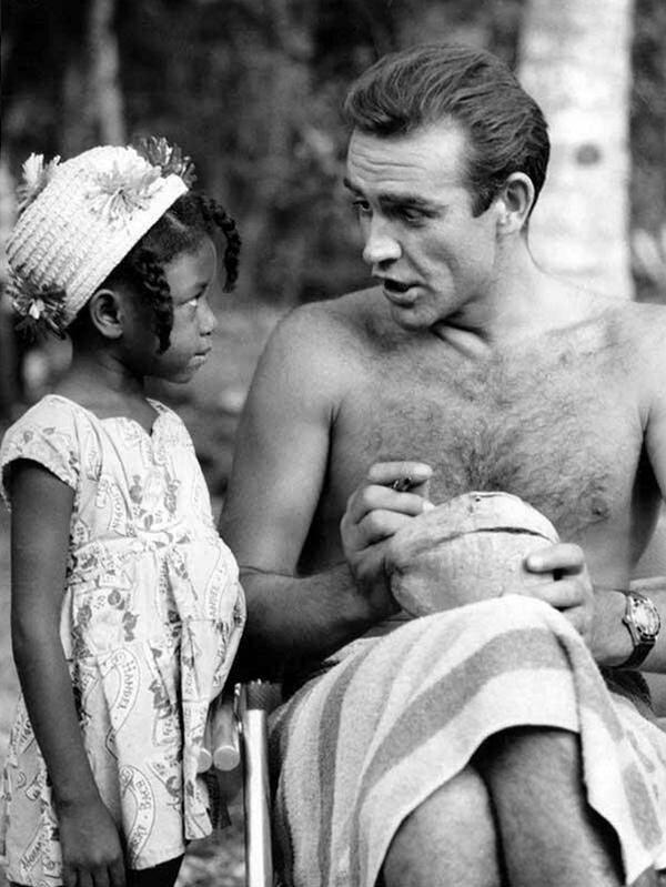 Шон Коннери подписывает кокос для маленькой фанатки из Ямайки на съемках фильма "Доктор Ноу", 1962 г