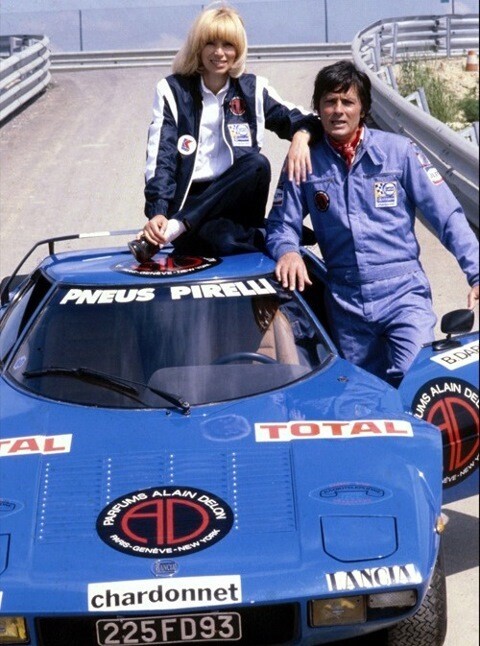 Делон и Мирей Дарк позируют у гоночной Lancia Stratos его собственной команды Alain Delon Racing Team