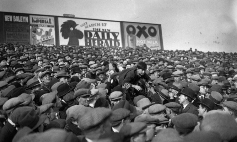 Болельщики Вест Хэма проносят мальчишку над своими головами ближе к полю, чтобы тот смог лучше видеть игру. Лондон, 1 марта 1930 года.