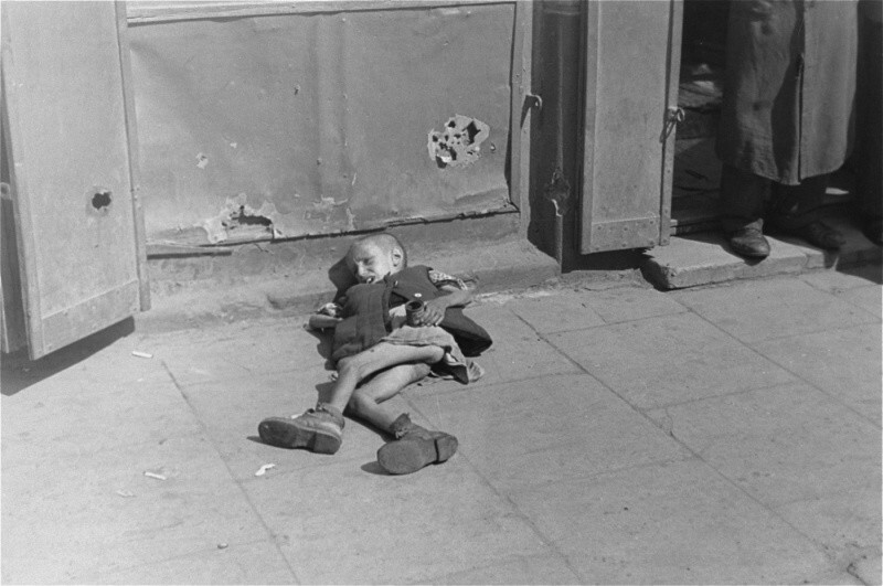 03. Истощенный ребенок, лежащий на тротуаре в варшавском гетто.