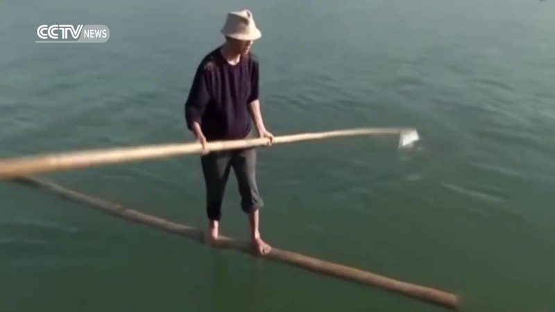 Китаец ежедневно плавает на работу на бамбуковой палке 