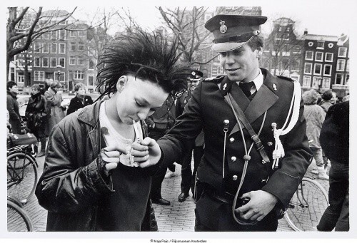 Полицейский даёт прикурить девушке–панку во время антиправительственной демонстрации в центре Амстердама, 1984 год, Нидерланды