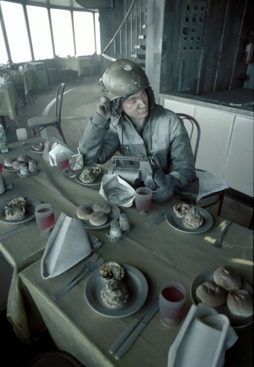Пожарный сидит за столом ресторана "Седьмое небо" Останкинской телебашни в Москве после пожара на ней, август 2000 года, Россия