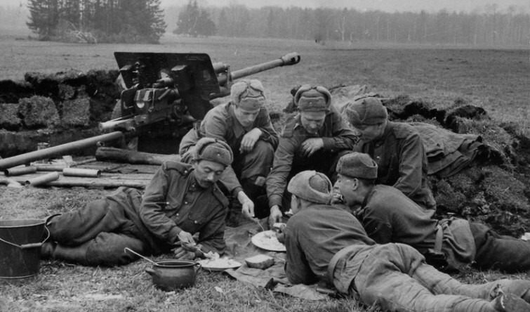 Советские артиллеристы обедают рядом с орудием. Окрестности Берлина. Апрель 1945 года  