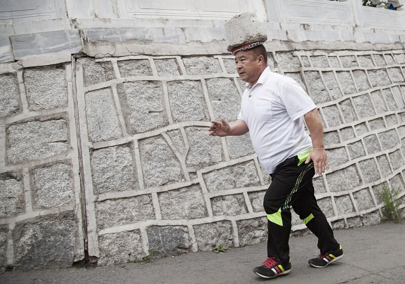 Ради похудения китаец гулял с 40-килограммовым камнем на голове