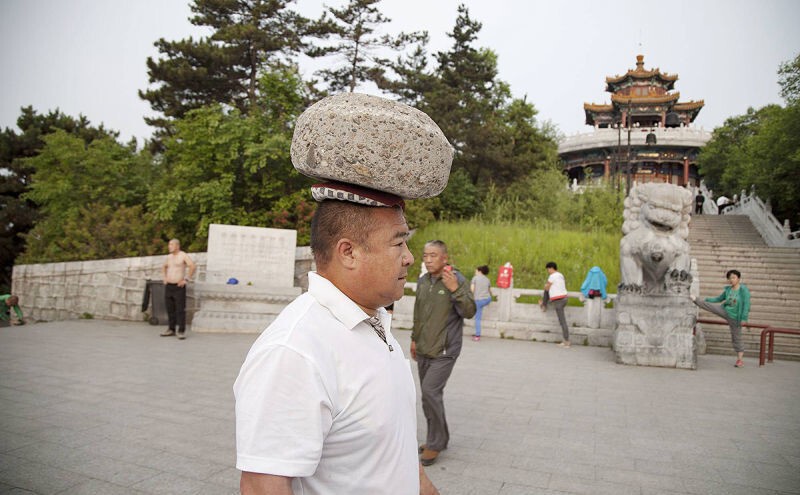 Ради похудения китаец гулял с 40-килограммовым камнем на голове