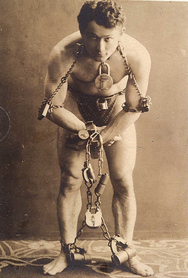 Фокусник Гарри Гудини позирует в своих легендарных цепях, 1899