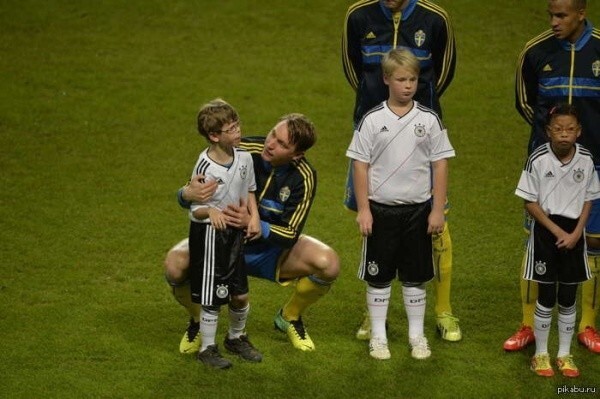 Футболист помогает мальчику аутисту успокоиться, так как он начал сильно волноваться перед матчем.