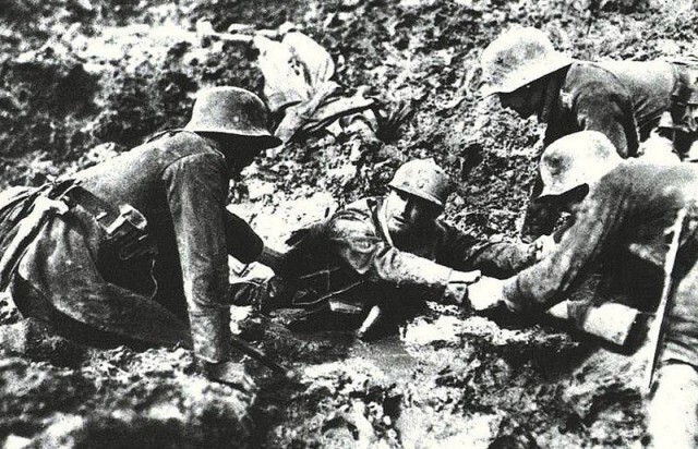 Немецкие солдаты помогают французу, застрявшему в болоте в Вердене. Первая мировая, 1916 год. 