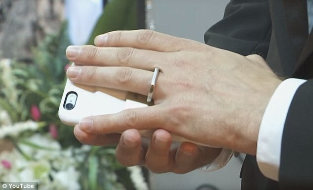 Когда настало время обмениваться кольцами, Аарон поднял смартфон и продел палец в кольцо, прикрепленное к чехлу. 