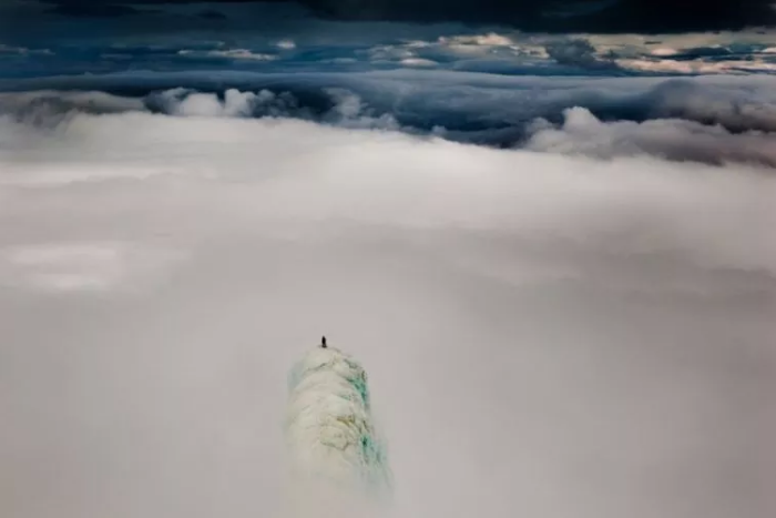 Одинокий альпинист на вершине горы в Исландии.
