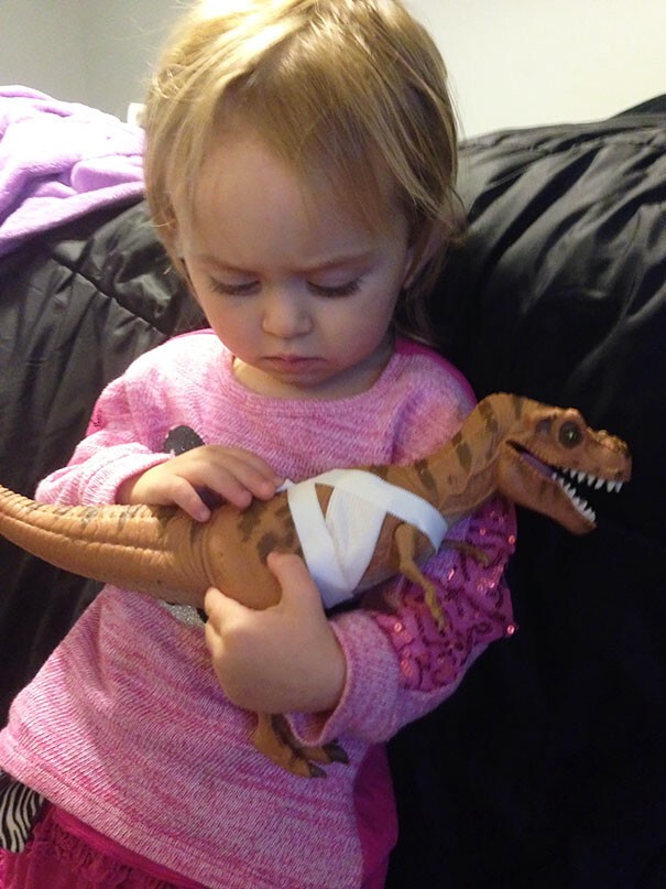 45. Двухлетняя девочка перевязала «раны» динозавра и теперь утешает его