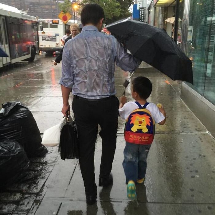 Отец отдает сыну зонтик