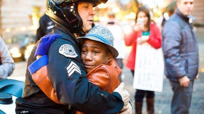 Полицейский обнимает плачущего мальчика
