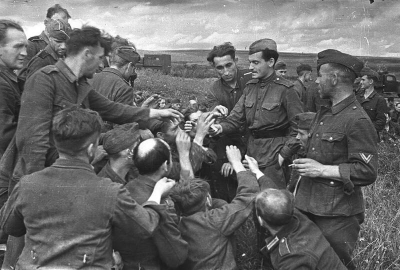 3. Советский солдат делится сигаретами с немецкими военнопленными. Вторая мировая, 1943 год.
