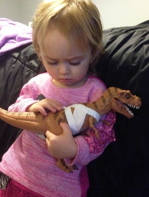 Двухлетняя девочка перевязала «раны» динозавра и теперь утешает его