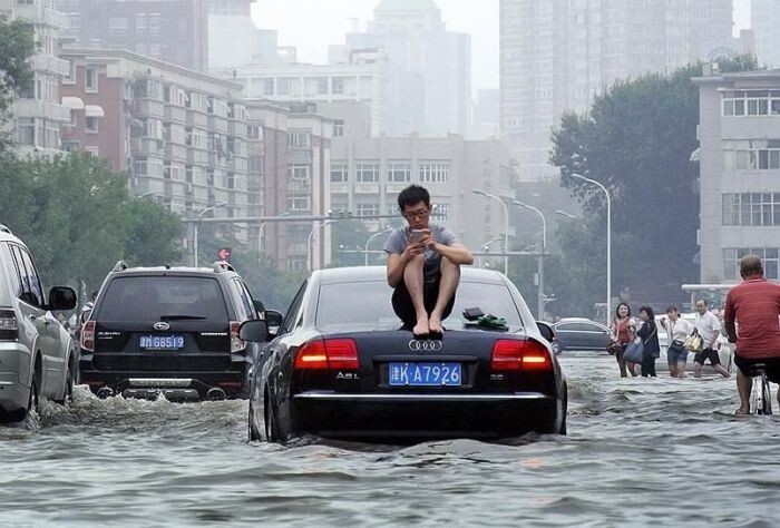 Мужчина спасается от наводнения в Тяньцзине