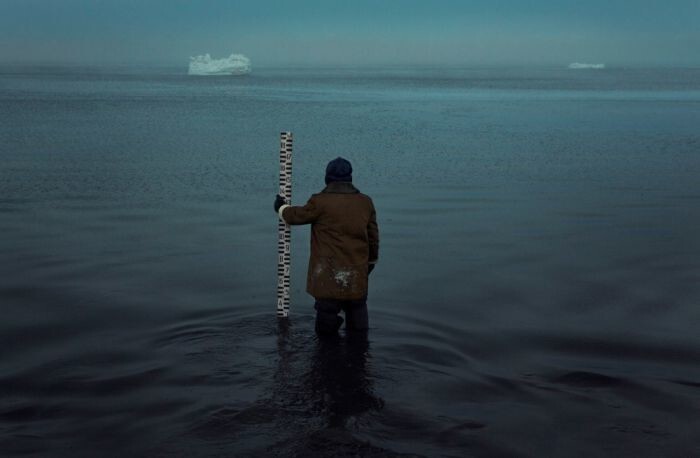 Короткий, стоя по колено в воде, замеряет уровень Баренцева моря.