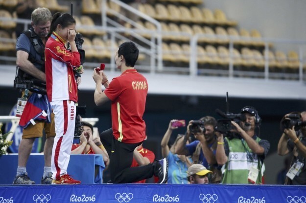 Ее возлюбленный Цинь Кай, который также входит в сборную Китая по прыжкам в воду, вышел на сцену и опустился на одно колено. 