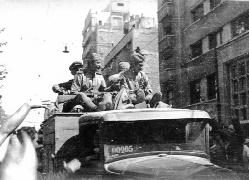 Советские солдаты в кузове грузовика ГАЗ-АА на улице освобожденного Бухареста.