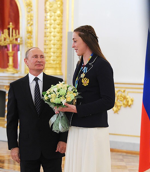Олимпийская чемпионка по гандболу Виктория Жилинскайте смотрит на президента сверху вниз. 