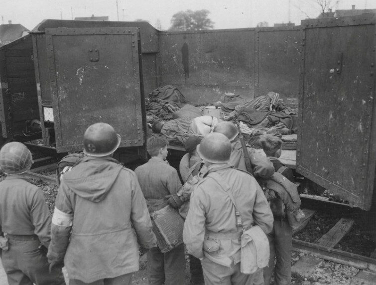 Американские солдаты показывают подросткам из «Гитлерюгенда» тела узников в вагоне, в концлагере Дахау, 1945 год  