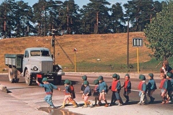 Маленький флажок в руке детсадовца останавливает движение на дороге. 1960-е.