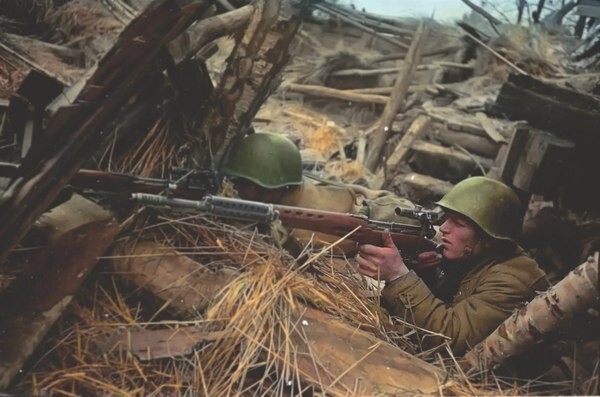 Советские снайперы с винтовками СВТ ведут огонь с позиции среди разрушенного сарая. 