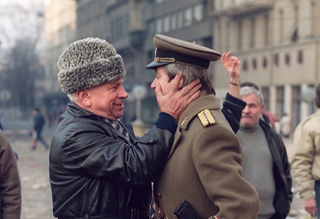 Мужчина обнимает офицера армии Румынии после казни супругов Чаушеску, 25 декабря 1989 ода