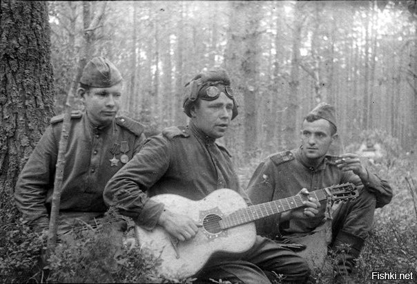 Советские бойцы слушают своего товарища, играющего на гитаре