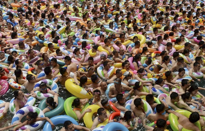 Посетители бассейна в уезде Даин (провинция Сычуань) задевают друг друга резиновыми кругами и не оставляют попыток расслабиться и отдохнуть.