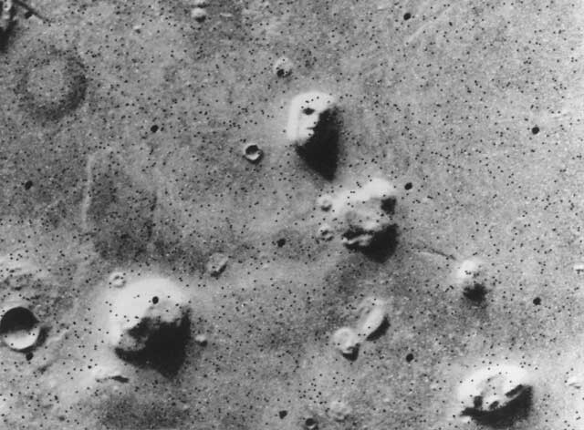 А здесь всем известное лицо на Марсе (NASA, 1976). Эта игра света и тени породила множество уфологических теорий о древних марсианских цивилизациях. На поздних снимках этого региона Марса никакого лица не обнаруживается.