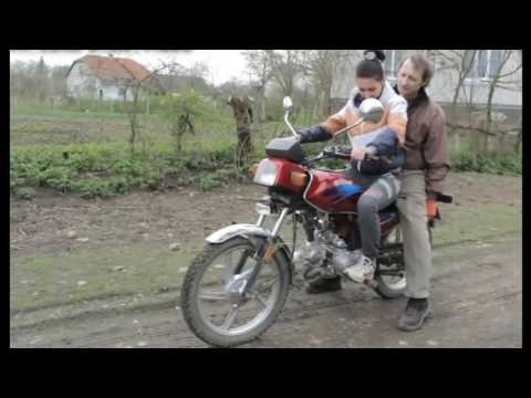 Отец учит дочь кататься на мотоцикле  