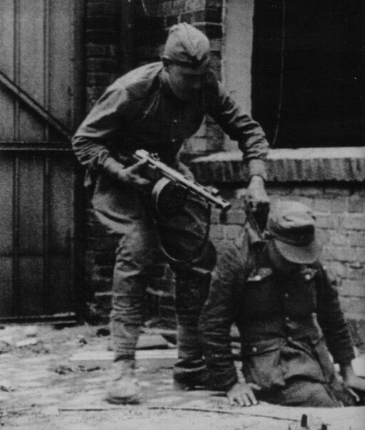 Советский солдат вытаскивает из люка немецкого солдата. Берлин.