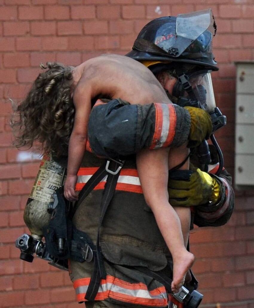 Пожарный выносит 6-летнюю девочку из горящего здания