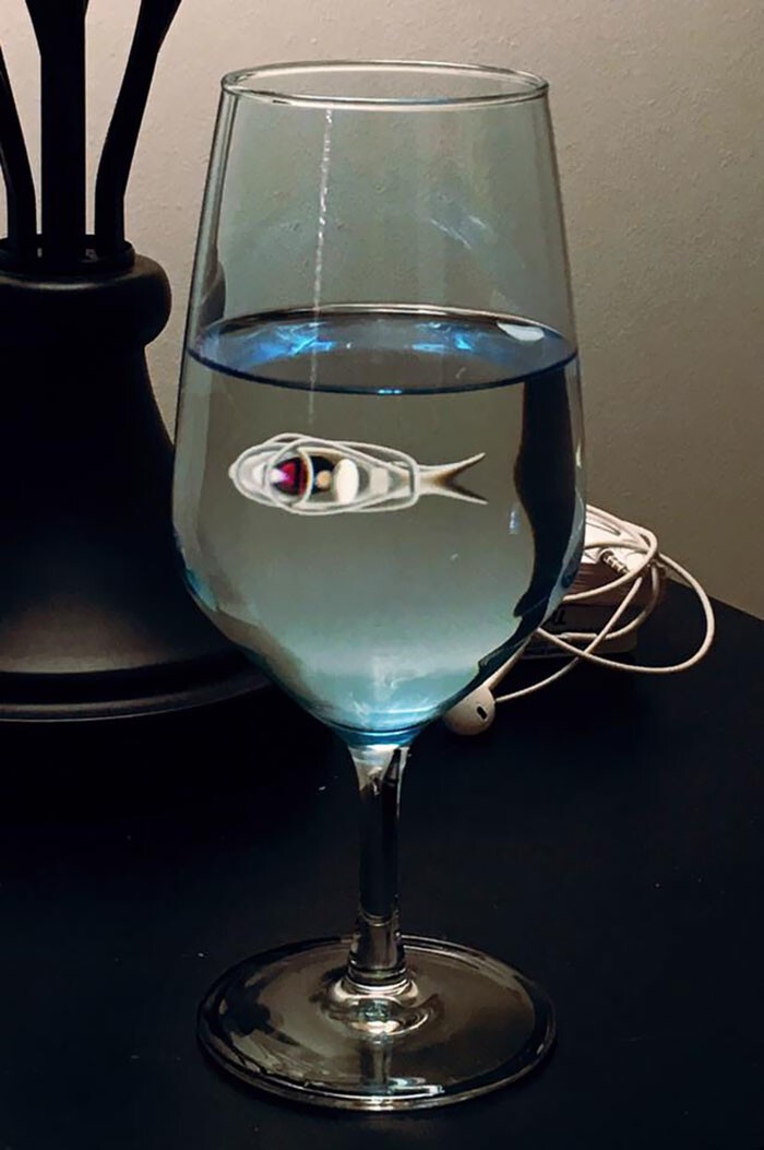 Электронная рыбка. Отражение наушников в бокале с водой