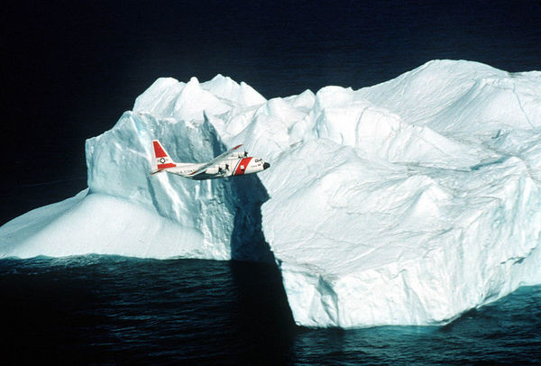 Самолет ледового патруля инспектирует айсберг
