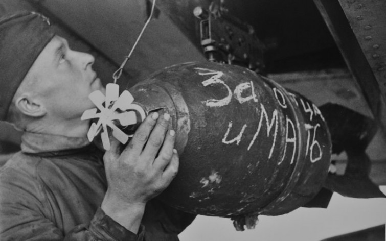 Советский оружейник загружает в бомбардировщик бомбу ФАБ-50 с надписью «За отца и мать», 1943 год  