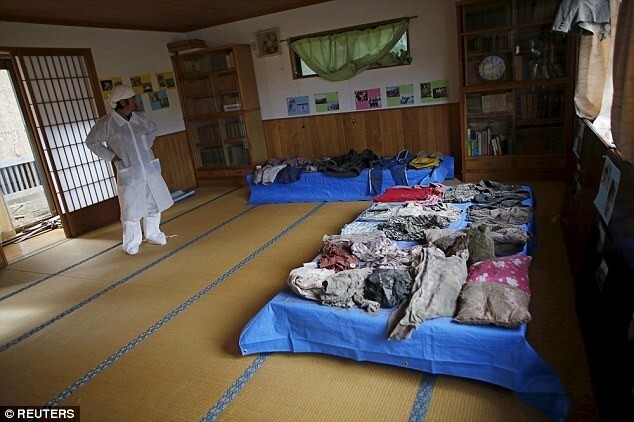 Г-н Кимура раскладывает найденные фрагменты одежды и вещи, которые принадлежали его семье