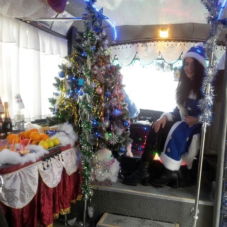 В этом году у водителя появилась помощница в костюме Снегурочки. Для всех пассажиров установлен стол с угощениями и детским шампанским, а в салоне играет новогодняя музыка.