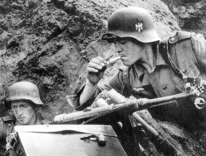 Немецкий солдат в окопе прикуривает сигарету. Курская дуга. 